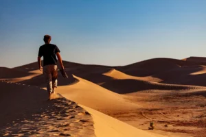 Man walking over a sand dune at Erg Lehoudi near Zagora