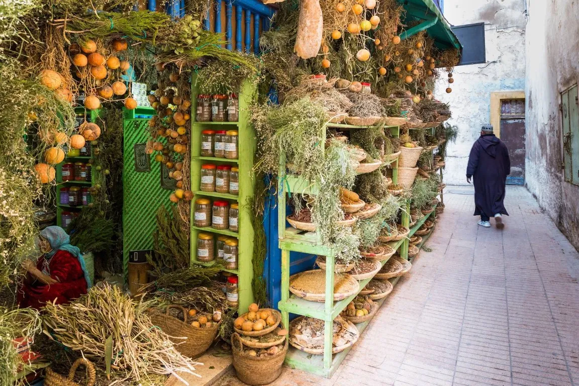 A boutique selling dried plants in the Medina of Essaouira, Morocco, showcasing colorful displays of dried herbs, flowers, and traditional Moroccan goods, part of the Essaouira Travel Guide.