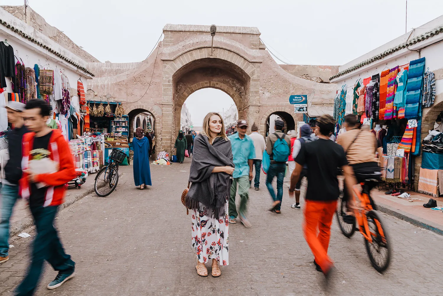 A view of the Medina of Essaouira, featuring narrow cobbled streets, whitewashed buildings with blue shutters, and vibrant market stalls, part of the Essaouira Travel Guide.