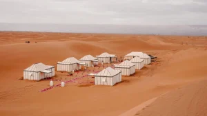 White tents of a desert camp in the Sahara dunes