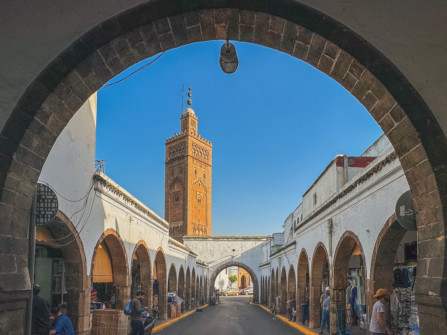 A sunlit, arched walkway in the Quartier Habous, showcasing the unique blend of Moroccan and French architecture