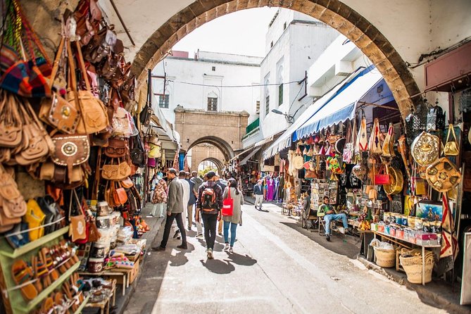 The Old Medina: "A vibrant, narrow alleyway in the Old Medina of Casablanca, with locals shopping for traditional crafts and goods."